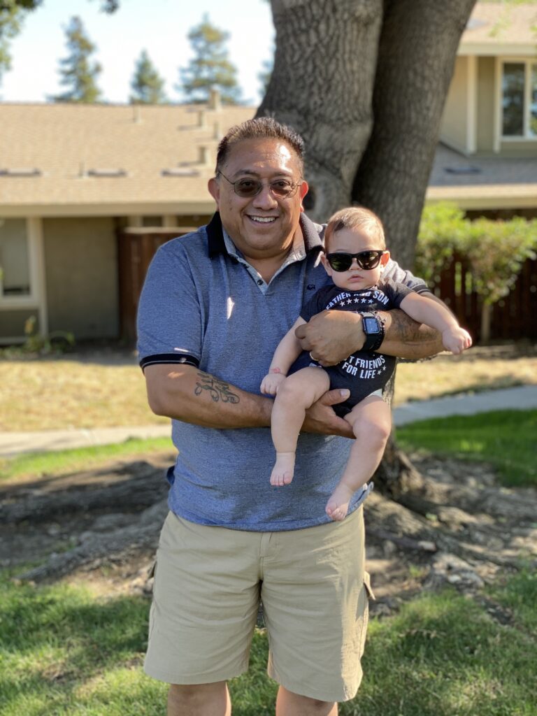 Ramon Parra, an Asbestos, Lead, Hazardous Materials and Construction Safety Instructor, Bay Area environmental training holding his grandbaby